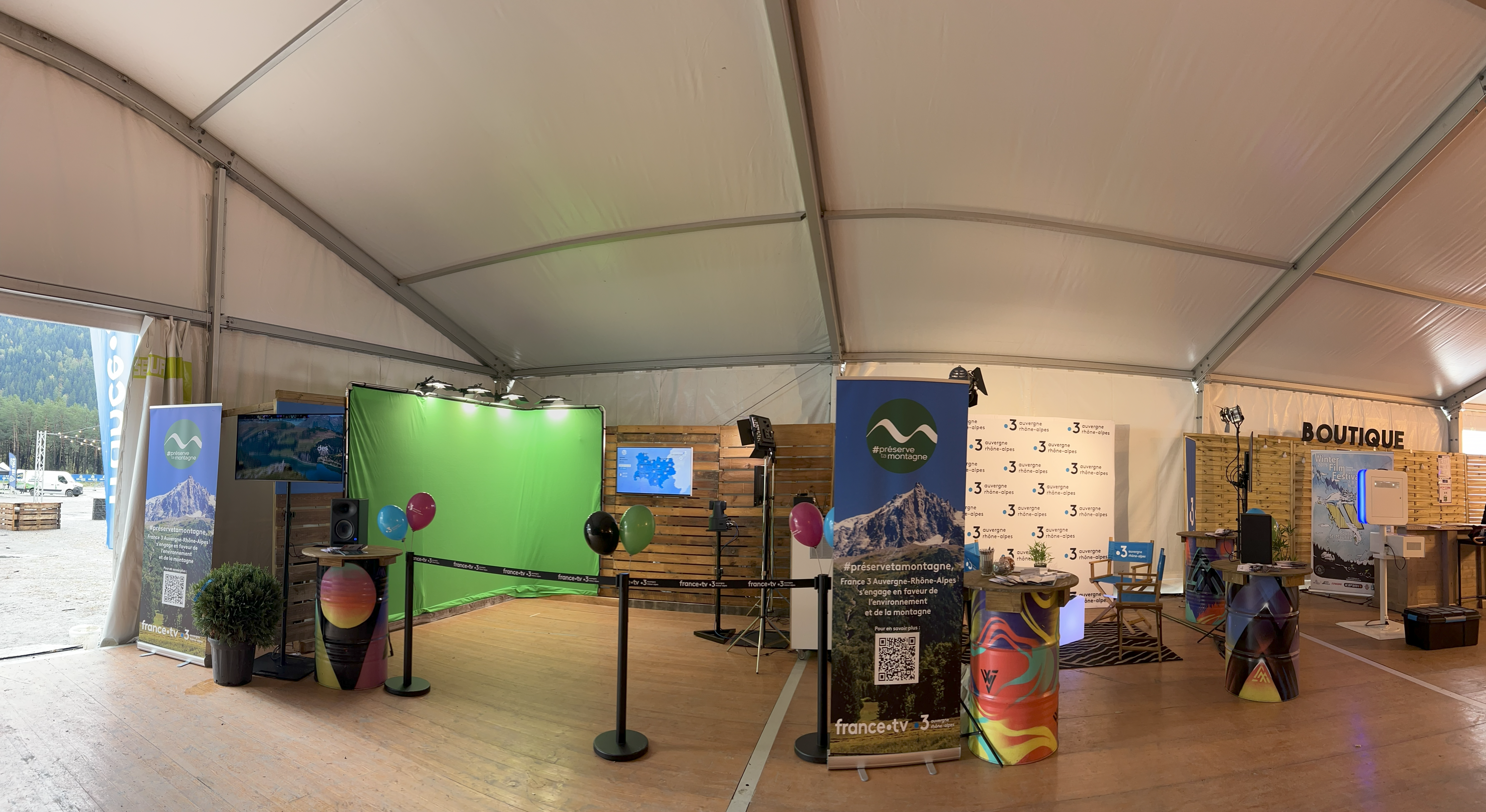 Studio fond vert au XPLORE 2023 avec écrans, éclairage, décor montagne et animations Medialab Factory.